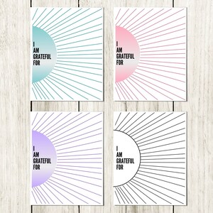 May include: Four printable cards with a sunburst design and the text "I am grateful for". The cards are in four different colors: teal, pink, purple, and black.