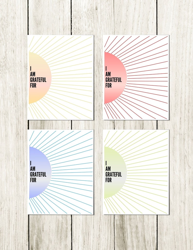 May include: Four printable cards with a sunburst design and the text "I am grateful for" in black. The cards are in four different colors: yellow, pink, blue, and green.