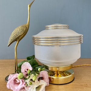 Lámpara de mesa vintage con forma de globo en cristal esmerilado blanco y dorado.