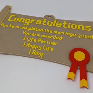 May include: A tan, scroll-shaped plaque with yellow pixelated text reading: Congratulations, You have completed the marriage quest! You are awarded: 1 Life Partner, 1 Happy Life, 1 Ring. A red and yellow ribbon seal is attached to the bottom right.