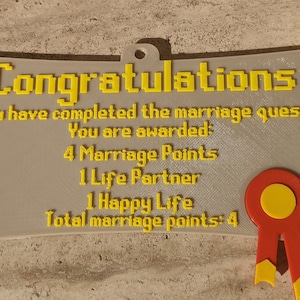 May include: A beige scroll-shaped plaque with yellow pixelated text reading: Congratulations, You have completed the marriage quest! You are awarded: 4 Marriage Points, 1 Life Partner, 1 Happy Life, Total marriage points: 4. A red and yellow ribbon is attached.