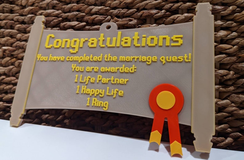 May include: A beige scroll-shaped plaque with yellow pixelated text reading: Congratulations, You have completed the marriage quest! You are awarded: 1 Life Partner, 1 Happy Life, 1 Ring. A red and yellow ribbon emblem is attached to the bottom right.
