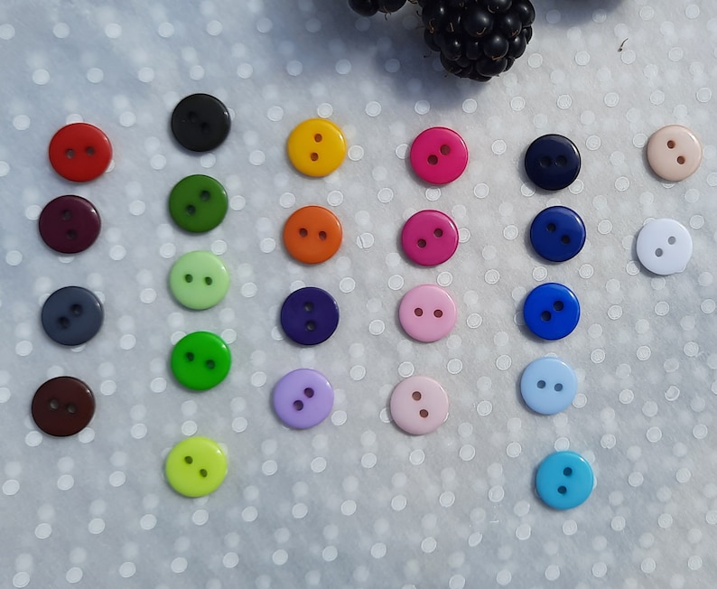 May include: Assortment of colorful two-hole buttons in various colors, including red, green, blue, yellow, purple, and white.