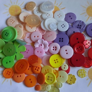 Peut inclure: Une collection de boutons colorés de différentes tailles et formes. Les boutons sont disposés dans un arc-en-ciel de couleurs, notamment le vert, le jaune, l'orange, le rose, le violet et le rouge. Certains boutons ont deux ou quatre trous, d'autres ont un motif floral.