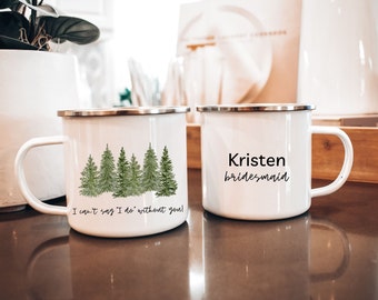Puede incluir: Dos tazas de esmalte blanco con texto negro y un diseño de acuarela verde de pinos. Una taza dice "No puedo decir que lo hago sin ti!" y la otra dice "Kristen dama de honor".
