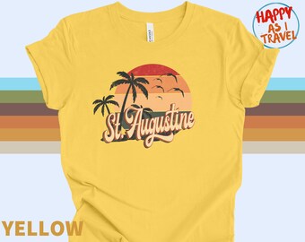 May include: Yellow t-shirt with a retro sunset graphic, palm trees, and the text "St. Augustine".