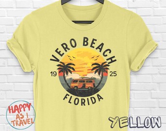 Puede incluir: Camiseta amarilla con un gráfico de estilo vintage de una escena de playa con una puesta de sol, palmeras y una camioneta retro. El texto "Vero Beach 19 25 Florida" está impreso en el gráfico.