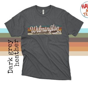 May include: Dark heather grey t-shirt with a vintage-style graphic that says "Wilmington, North Carolina".