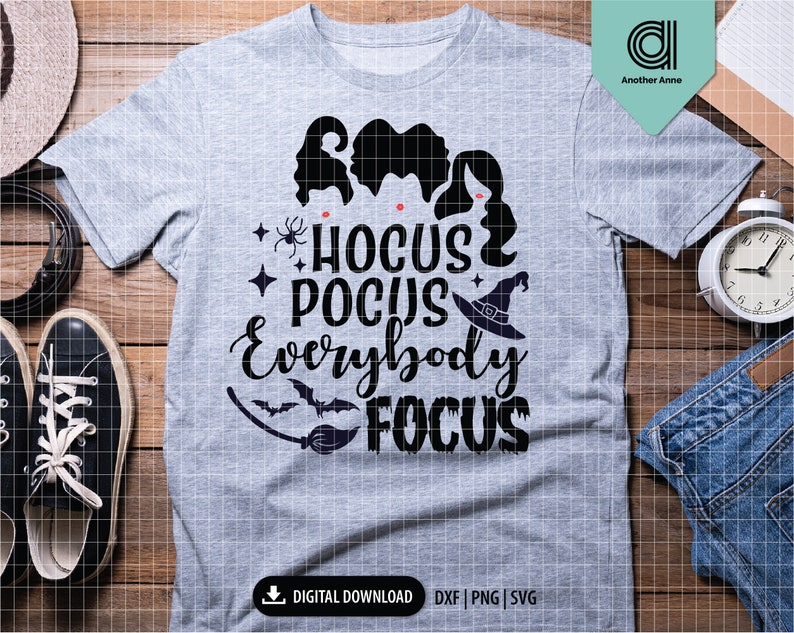 May include: A heather gray t-shirt with the text "Hocus Pocus Everybody Focus" in black. The design includes silhouettes of three witches, a witch hat, a spider, and a bat. The shirt is a digital download.