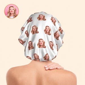 May include: White satin shower cap patterned with a woman's face blowing a kiss. The cap is viewed from the back, with a small circular image of the woman's face in the upper left corner.