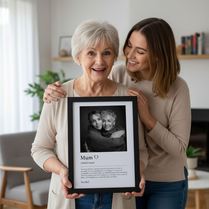 An older woman and younger lady holding a black frame showing a black & white photo and description of 'Mum' below with customisable name.