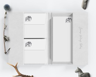 May include: A set of white stationery with a gray elephant illustration on each sheet. The stationery is packaged in a white box with the text "Fancy Writing Notes" printed on the side.