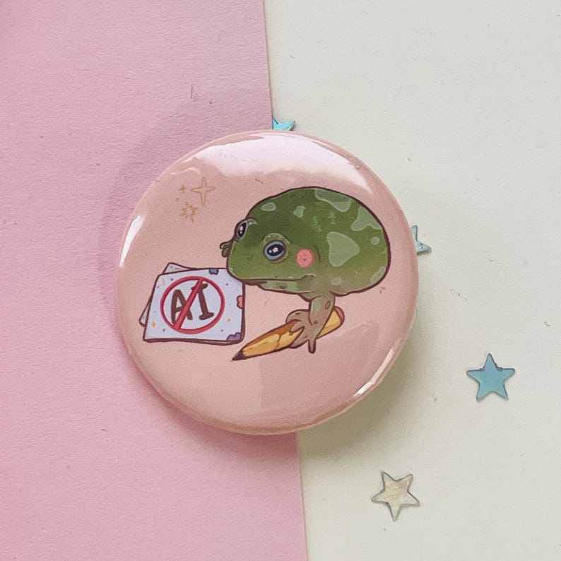 May include: A pink button with a green frog holding a pencil and a piece of paper with a red circle and the letters "A1" crossed out.