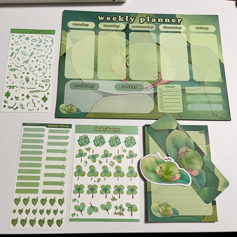 May include: A set of green and white planner stickers featuring a weekly planner, planner blocks, lucky leaves, and plan & sparkle stickers. The weekly planner has sections for Monday through Sunday, with a reminder section. The planner blocks include various shapes and sizes of green rectangles, stars, and hearts. The lucky leaves sticker sheet features multiple green four-leaf clovers. The plan & sparkle sticker sheet features green swirls, stars, and other shapes.