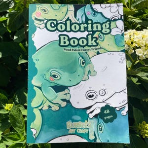 May include: A coloring book titled "Coloring Book" with the subtitle "Pond Pals & Forest Friends." The cover features illustrations of green and white frogs. The book has 48 pages and is branded "Bubbles Art Craft."