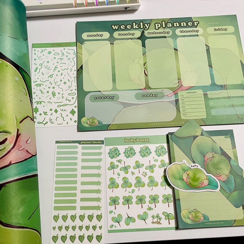 May include: A set of green and white planner stickers featuring a frog theme. The stickers include a weekly planner, planner blocks, lucky leaves, and plus & sparkle stickers. The stickers are perfect for adding a touch of whimsy to your planner.