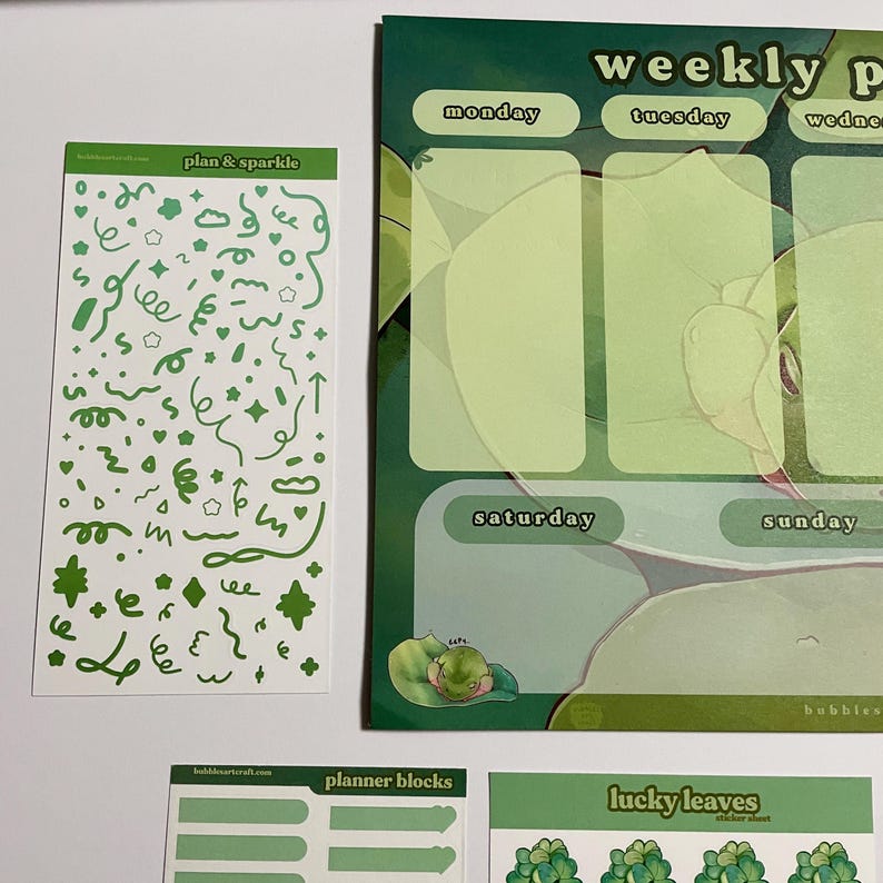 May include: A set of green and white planner stickers with a weekly planner page in the background. The stickers include a sheet of green doodles, a sheet of planner blocks, and a sheet of lucky leaves.