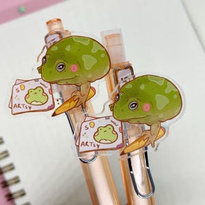 à bille Artsy Frog | 0,5 mm d'encre à séchage rapide | Breloque grenouille amovible de 3,5 cm | Parfait pour les artistes et les amateurs de grenouilles | Joli cadeau de papeterie