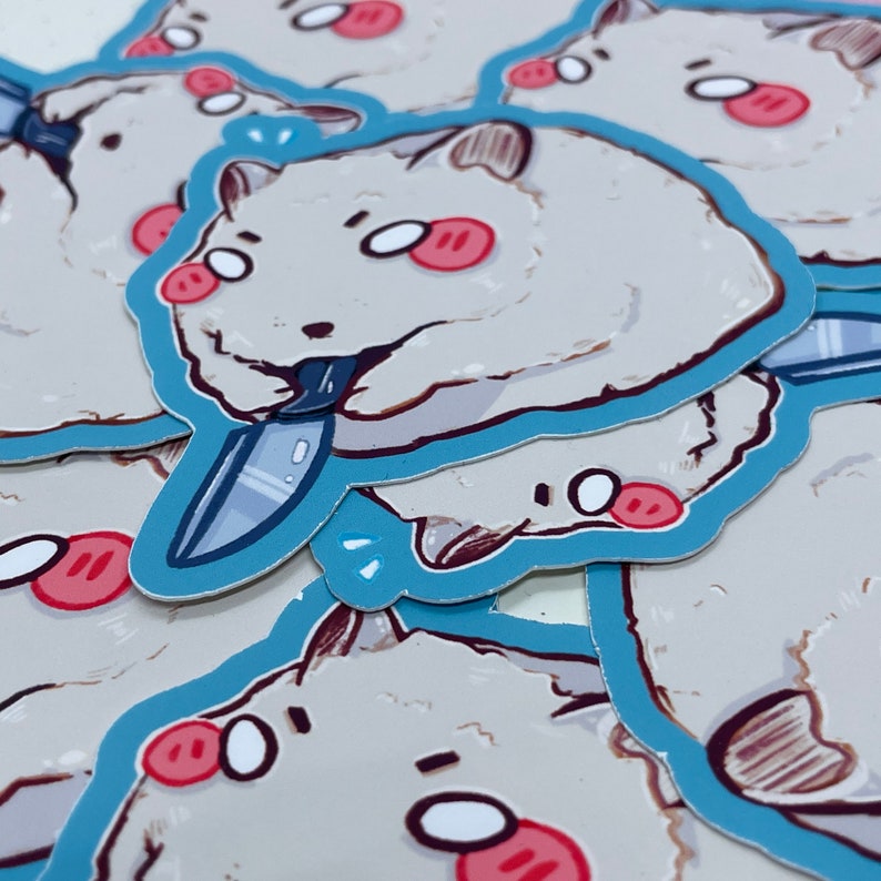 May include: A stack of stickers featuring a cartoon white fluffy animal holding a knife. The animal has large eyes and red cheeks. The stickers are outlined in blue.