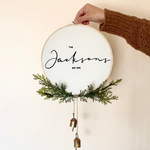Custom 10 Family Name Hand Embroidered Wall Hanging, Wreath, Wall Decor, Greenery, Brass Bells, Minimal, Christmas, Winter, Personalized imagem 1