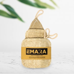 May include: A beige loofah kitchen sponge with a brown label that reads "EMARA www.emarausa.com Zero Waste Loofah Kitchen Sponge Organic | Vegan | 100% Compostable"