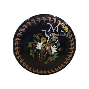 May include: Round black marble table top with a floral design inlaid with colorful stones. The table top is surrounded by a decorative border of brown and gold leaves.