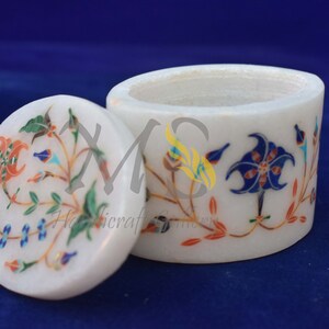 Può includere: Scatola per gioielli in marmo bianco con un design floreale intarsiato con pietre colorate. Il coperchio e la scatola sono decorati con motivi intricati.