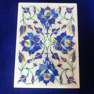 May include: A white marble box with a floral design inlaid with blue, green, and red stones. The box is decorated with a floral pattern and the text "Handicraft Gallery".