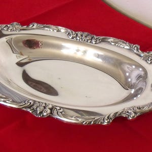 May include: A set of three ceramic mugs with a speckled, cream-colored glaze. Each mug features a different hand-painted design: a blue and green leaf, a yellow flower, and a red berry. The mugs have a simple, modern design.