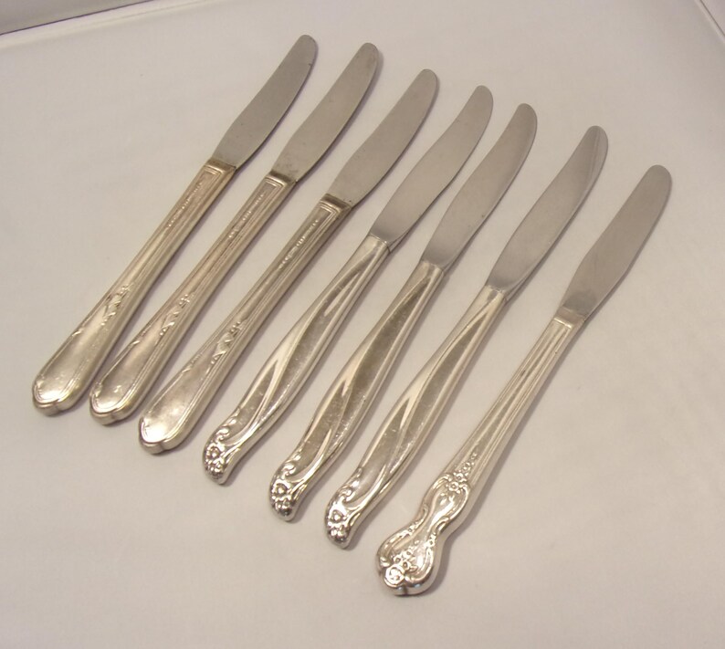 Puede incluir: Conjunto de siete cuchillos de mantequilla plateados. Los cuchillos tienen un dise&ntilde;o sencillo y elegante con un mango ligeramente curvado y una hoja lisa y puntiaguda. Los mangos presentan patrones florales y lineales decorativos.