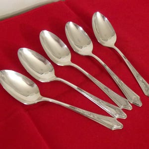 May include: A white ceramic mug with a black handle and the text "But First, Coffee" in a black, bold font. The mug is on a white surface.