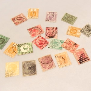 May include: A collection of vintage postage stamps in various colors, including green, orange, pink, and purple. The stamps feature intricate designs and postmarks, showcasing historical postal art. Some stamps have portraits and text.