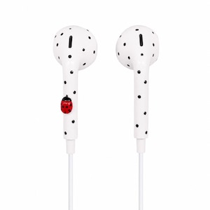 May include: A pair of white wired earbuds featuring a black polka dot pattern across the surface. One earbud is decorated with a small, three-dimensional red ladybug with black spots attached to the side of the stem, while the other is plain.