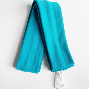 以下が含まれることがあります： 白い紐が付いたターコイズブルーの腕カバーのペア