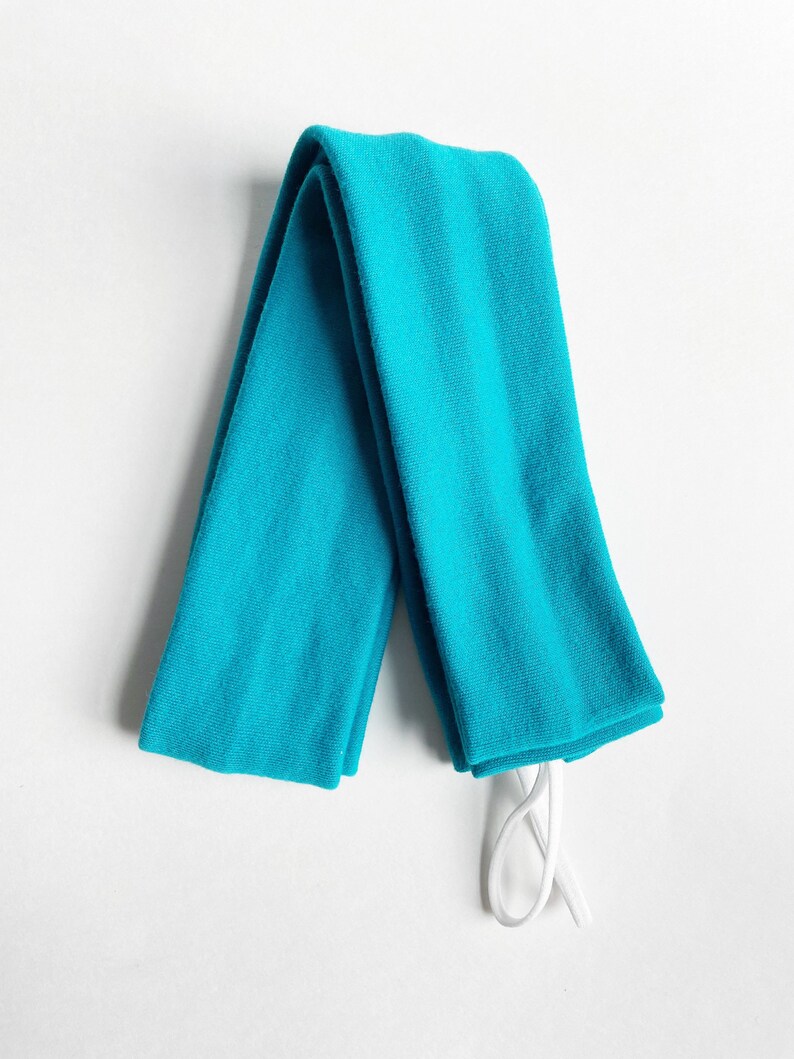 以下が含まれることがあります： 白い紐が付いたターコイズブルーの腕カバーのペア