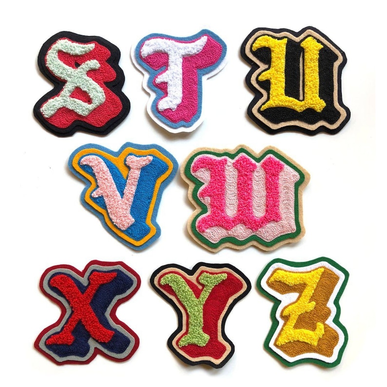 May include: A collection of embroidered letter patches in various colors. The letters include S, T, U, V, M, X, Y, and Z. Each patch has a unique color scheme, with details like red, pink, yellow, blue, and green.