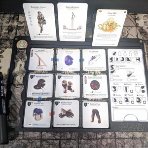 May include: A tabletop role-playing game setup featuring cards with illustrations and text, including "Rawhide Armor" and "Dung Milk." A black dry-erase marker and a game board with various slots and a survival tracker are also present.