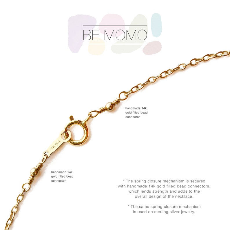 Puede incluir: Primer plano de un cierre y cadena de collar dorados. El cierre est&aacute; conectado con conectores de cuentas rellenas de oro de 14k hechos a mano. El texto "BE MOMO" est&aacute; en la parte superior. El mecanismo de cierre de resorte est&aacute; asegurado.