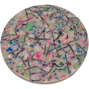 May include: A circular object with a speckled, multi-coloured surface. The surface is mainly white with embedded pieces of blue, pink, green, and other colours. Thin, black lines are scattered across the surface.