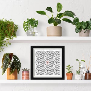 Fox embroidery pattern framed in a square frame on a plant shelf