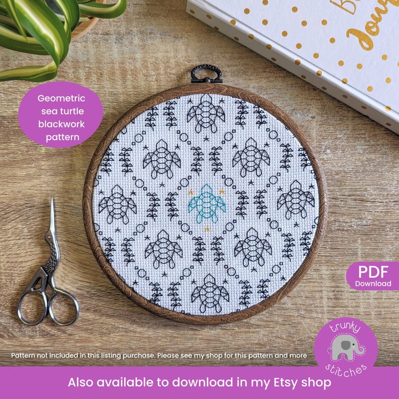 May include: A round, wooden embroidery hoop featuring a geometric sea turtle blackwork pattern. The design includes black turtles, trees, and stars on a white background. A pair of silver scissors and text that reads "Geometric sea turtle blackwork pattern" are also visible.