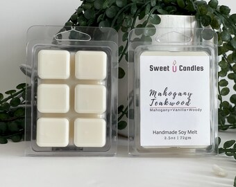 May include: Two clear plastic clamshells containing ivory-colored wax melts. One package shows six square melts, the other displays a label with "Sweet U Candles" and "Mahogany Teakwood" text. The label also states "Handmade Soy Melt" and 2.5oz | 72g.