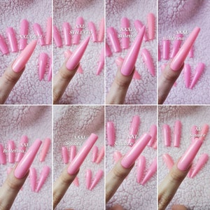 Peut inclure: Un ensemble d'ongles artificiels en acrylique rose de diff&eacute;rentes formes et tailles, notamment ovales, en stiletto, en ballerine et carr&eacute;s. Les ongles sont &eacute;tiquet&eacute;s avec leur taille et leur forme.