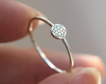 Op de afbeelding: Een zilveren ring met een delicaat levensbloemontwerp. De ring is eenvoudig en elegant, perfect voor dagelijks gebruik.