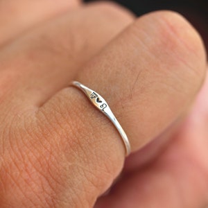 May include: A silver ring with a heart and the zodiac symbol for Virgo engraved on it.