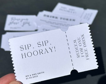 May include: White ticket with black text that reads "SIP, SIP, HOORAY!" and "REDEEM FOR ONE FREE DRINK". The ticket also includes the text "MR & MRS SMITH 01.03.2022".
