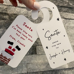 May include: Two white Christmas door hangers. One says "Santa please stop here. I've been really good this year. From, Frankie." The other says "Santa please stop here for Joseph + Harry."