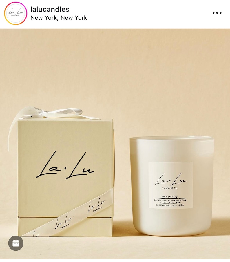 May include: A white candle jar with a white lid and a white box. The candle jar has a black label with the text "La.Lu Candles & Co. Let's get Cozy Vanilla Bean, White Musk & Wood Handcrafted in NYC 100g Soy Wax - 16 oz | 350g"