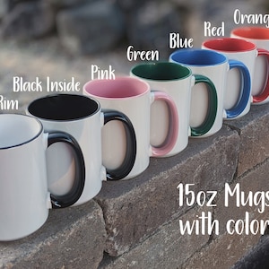 May include: Seven 15oz mugs with different colored rims. The mugs are white with black handles. The colors of the rims are black, pink, green, blue, red, and orange. The text "15oz Mugs with color" is written below the mugs.