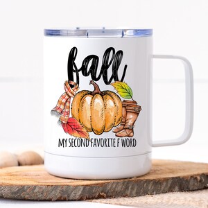 May include: White stainless steel travel mug with a black and white graphic of a pumpkin, leaves, and boots. The text "fall" is written in black cursive above the pumpkin and the text "my second favorite f word" is written below the pumpkin.